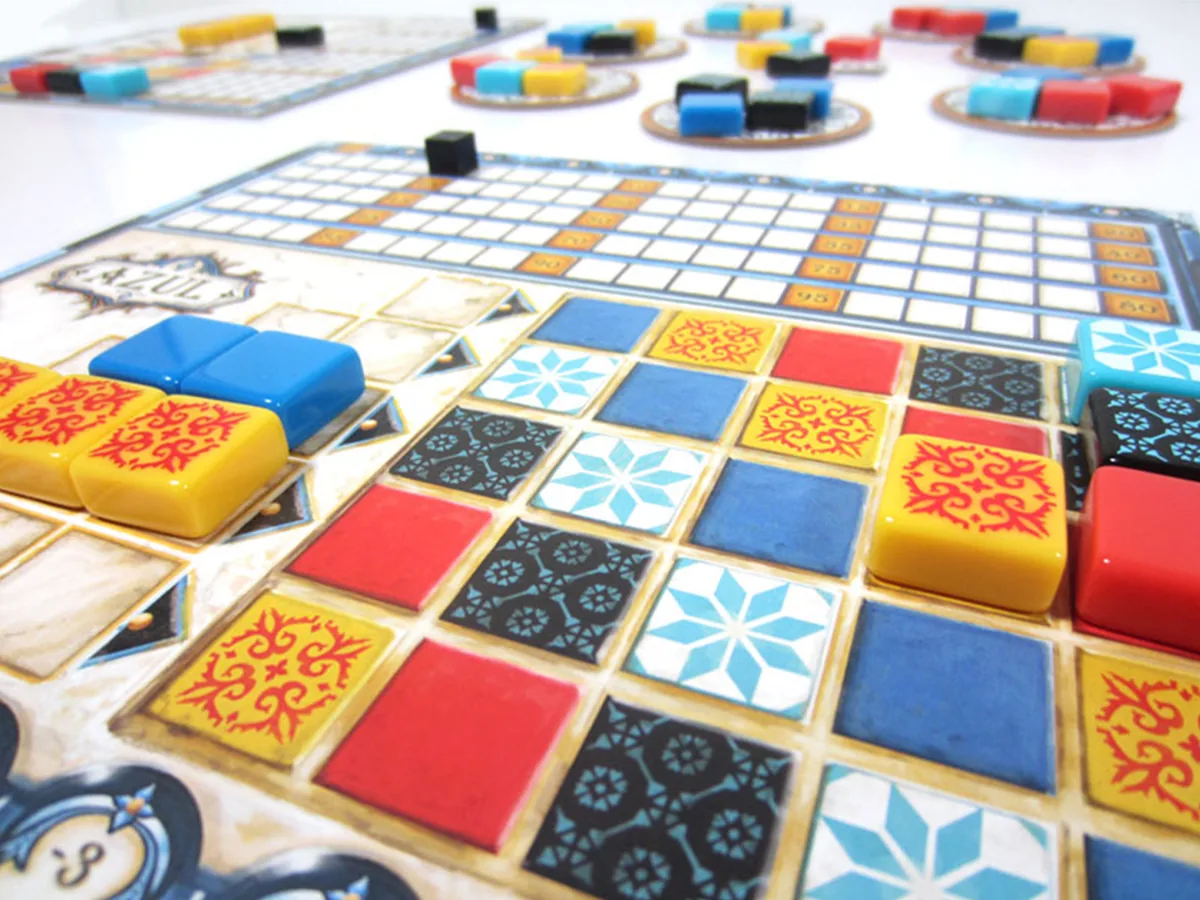 Close-up of a player board with chunky resin tiles lined up in the pattern rows