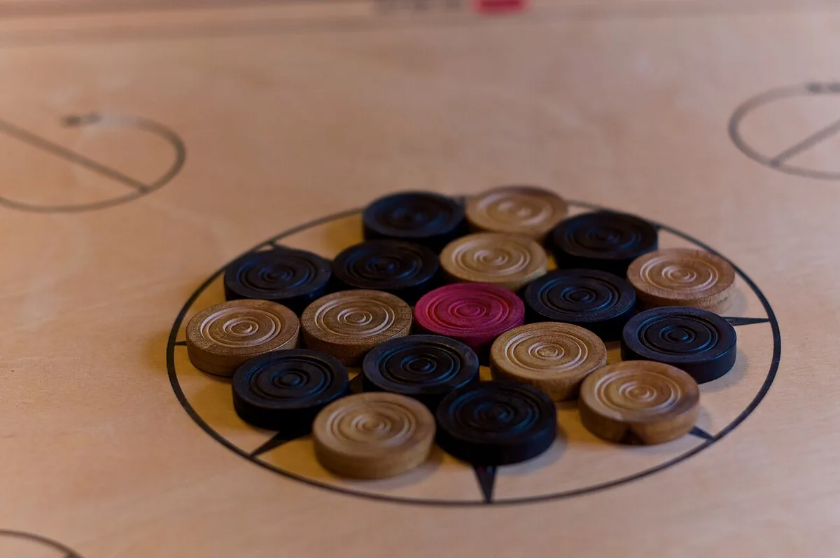 The carrom coins arranged in their starting ring around the red queen