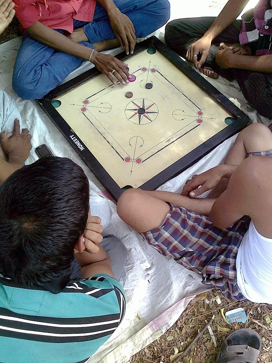 Teenagers in Chinawal, Maharashtra, playing carrom on the floor on a summer afternoon