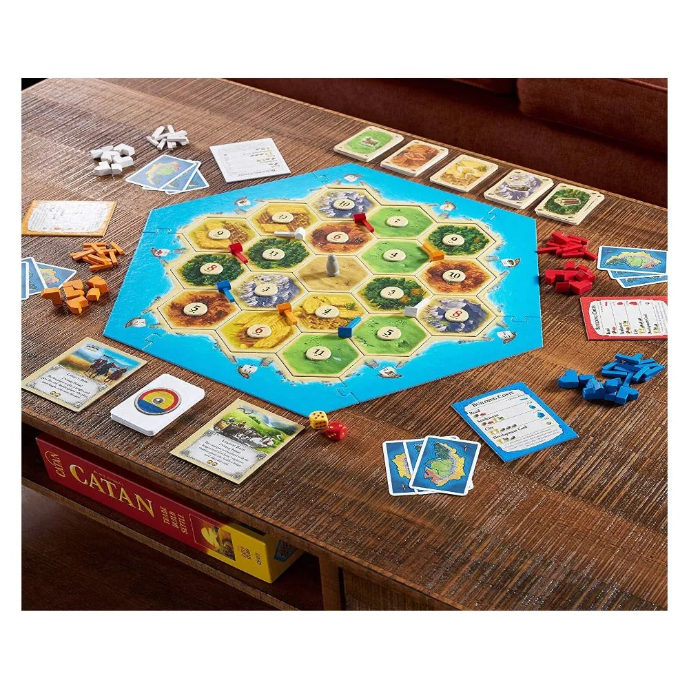 A game in progress on a wooden coffee table: the island board with roads and settlements, cards and pieces around it, and the Catan box on the shelf below