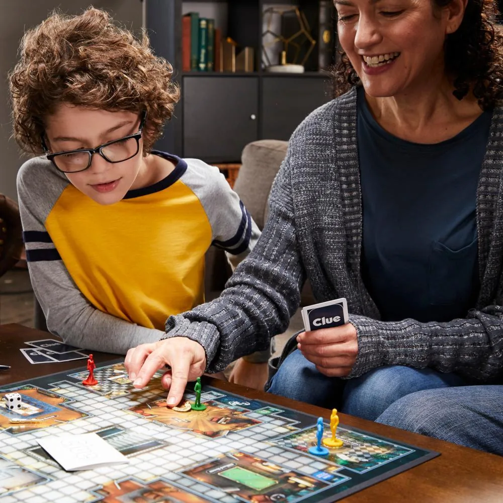 A mother and son playing Cluedo, the boy moving a pawn on the board