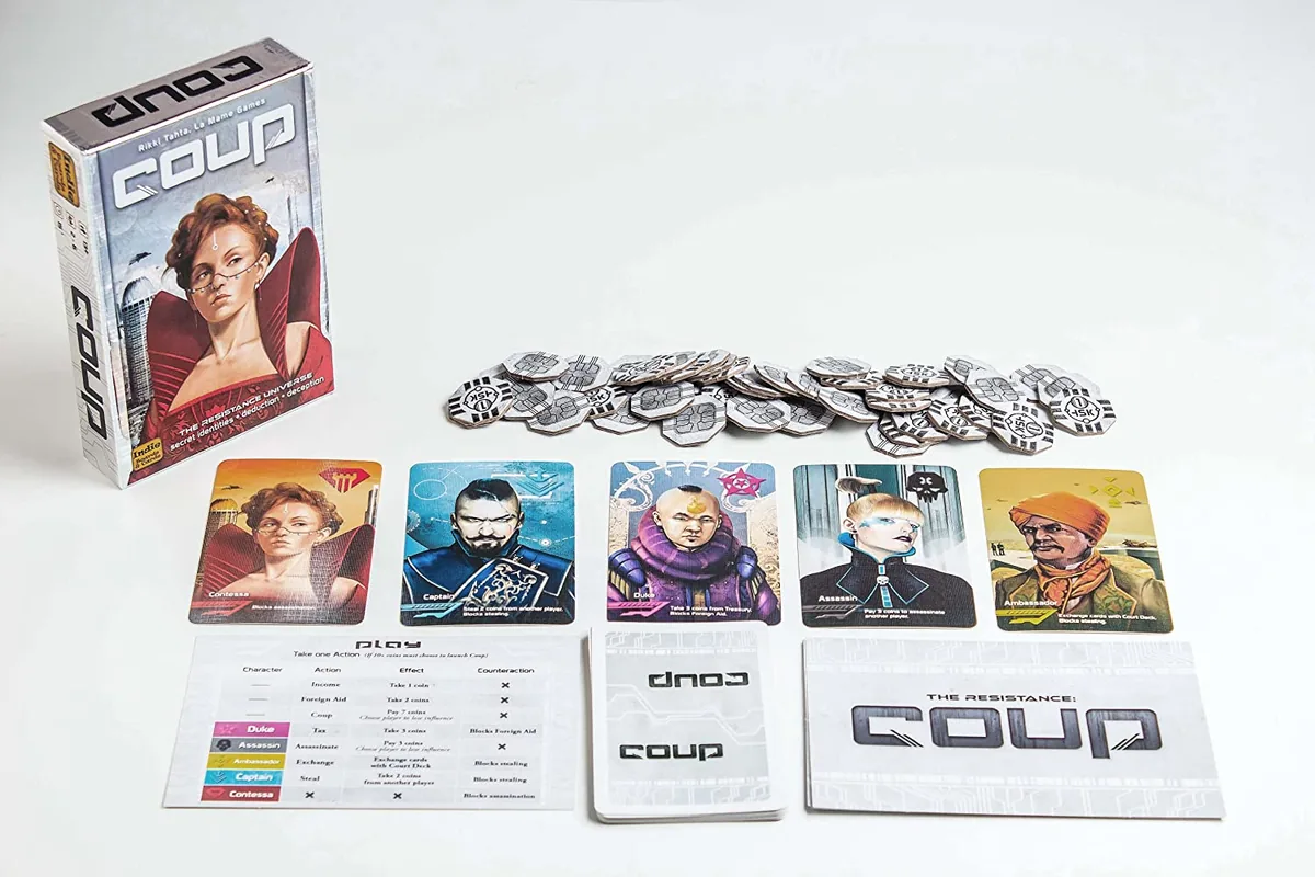 The Coup box, character cards, coins, summary cards and rules laid out