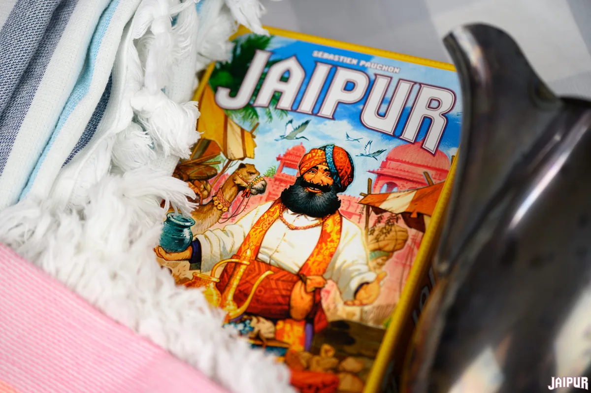 The Jaipur box lying on a soft rug next to a silver pot