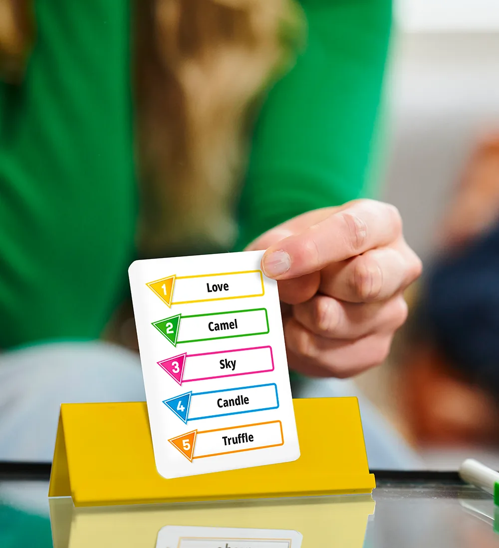 A hand placing a word card with five numbered words on a yellow easel