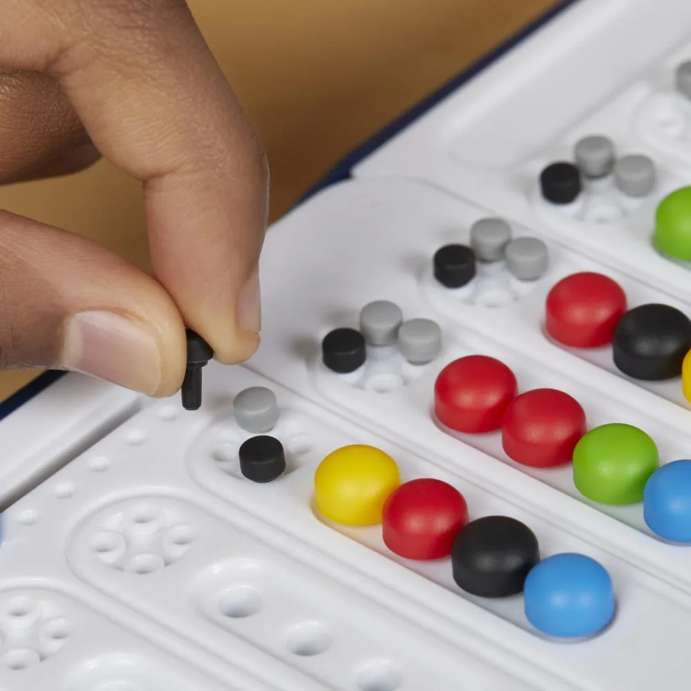 Close-up of a hand placing small key pegs beside a row of coloured code pegs