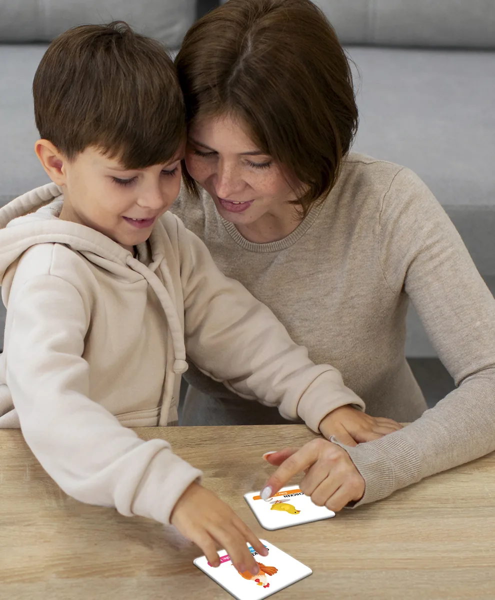 A woman and a young boy turning over memory cards on a table