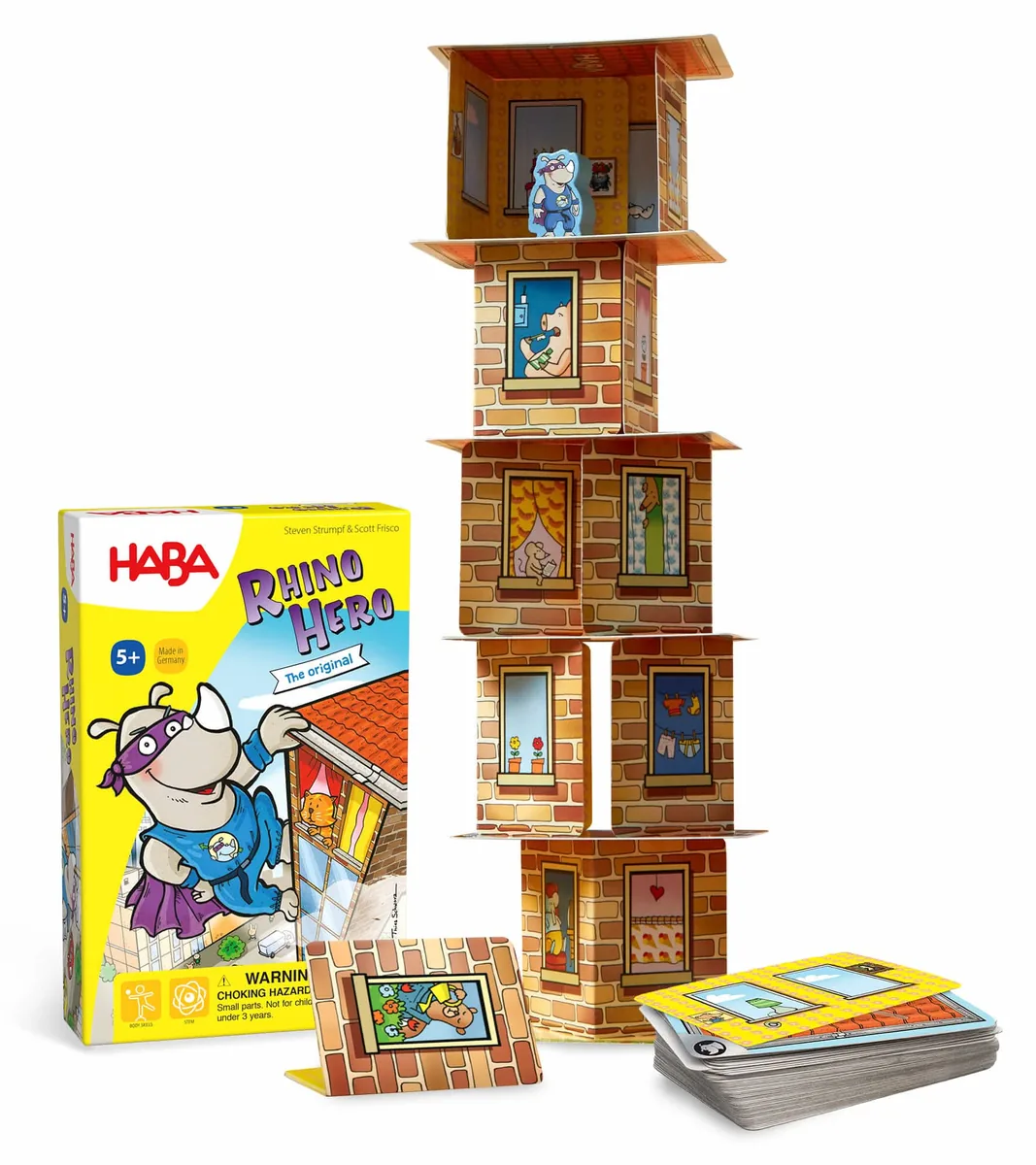 The Rhino Hero box beside a tall tower built from its roof and wall cards, with spare cards in front