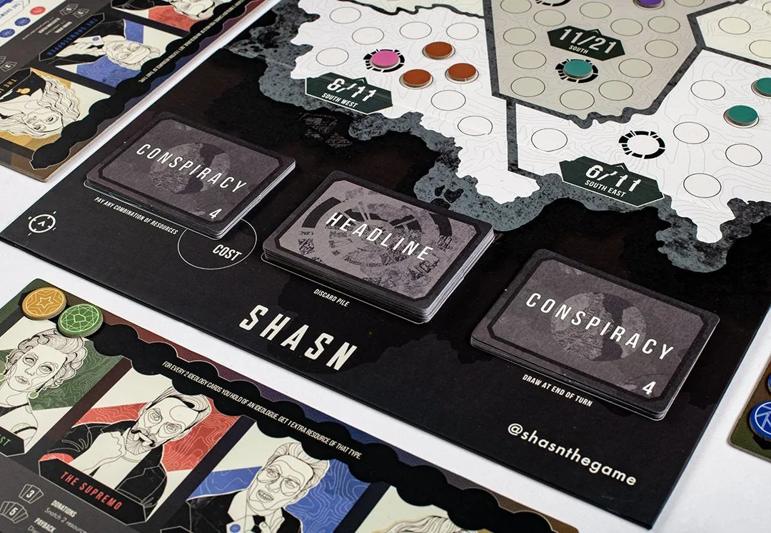 The Conspiracy and Headline card decks on their spaces beside the SHASN board