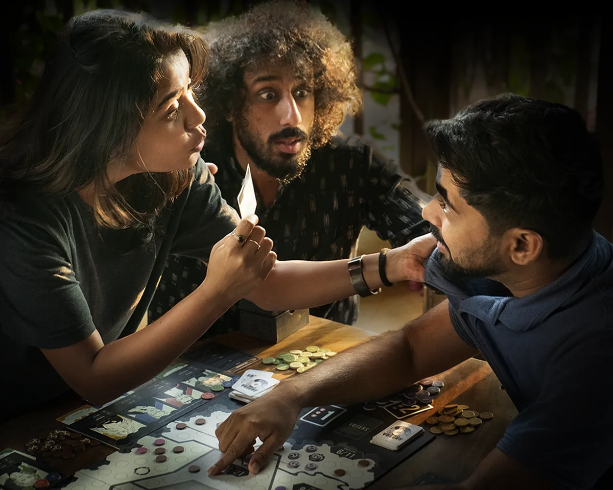 Three players leaning in over the SHASN board in a staged publisher photo