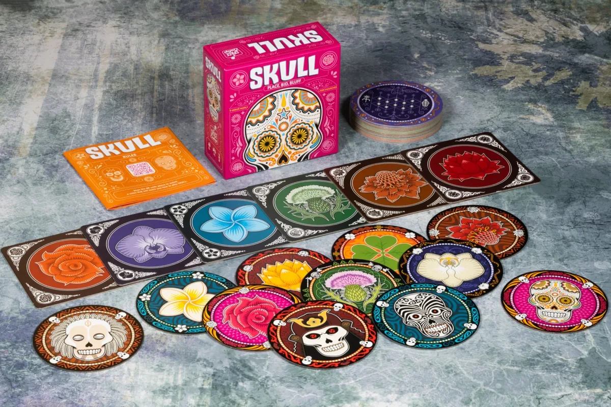The Skull box with six player mats and their discs laid out on a grey table