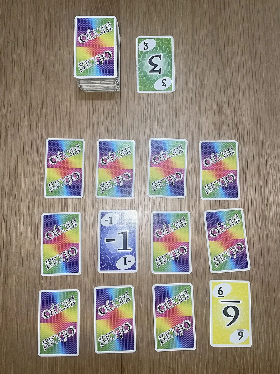 A player's grid of twelve SKYJO cards, three rows of four, a few turned face up