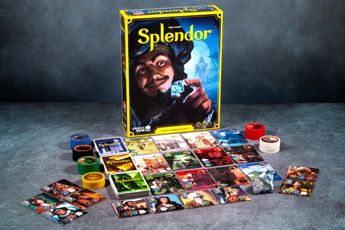 Splendor set up on a grey table: three rows of cards, gem stacks and the box behind