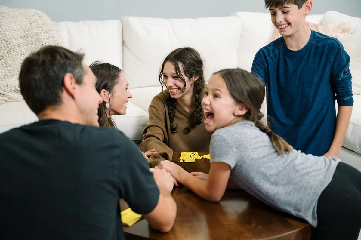Four players laughing as they race to slap the pile