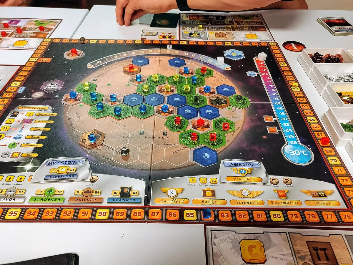 A Terraforming Mars board mid-game, with city, greenery and ocean tiles and cards around it