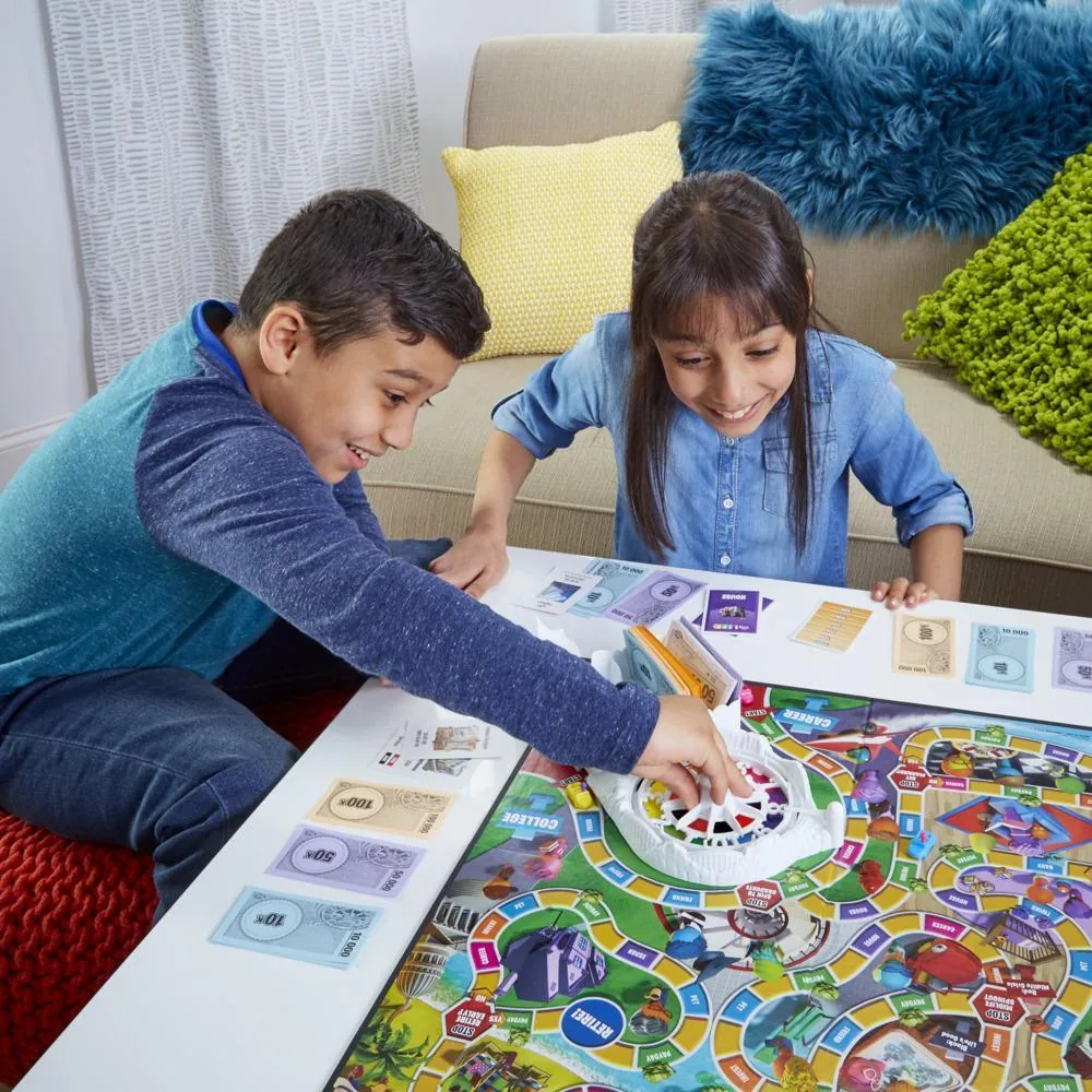 A boy and a girl leaning over the board, one moving a car