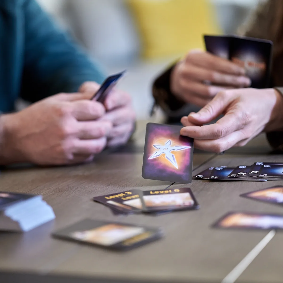 Two players at a table, one about to play a card onto the pile