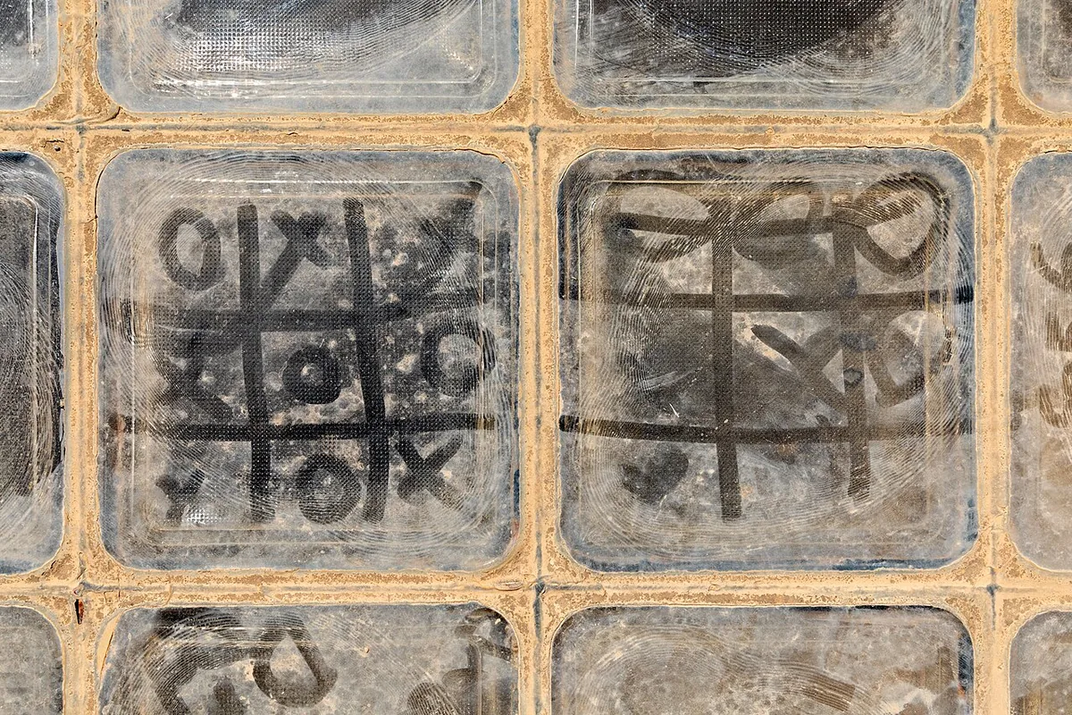 Noughts and crosses drawn in the dust on glass floor blocks in a fortress in Crete