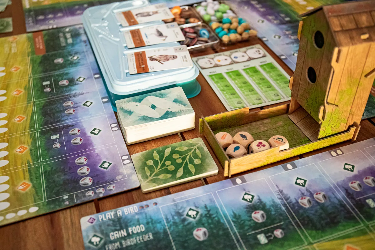 Close-up of the birdhouse dice tower, the food tray and player mats